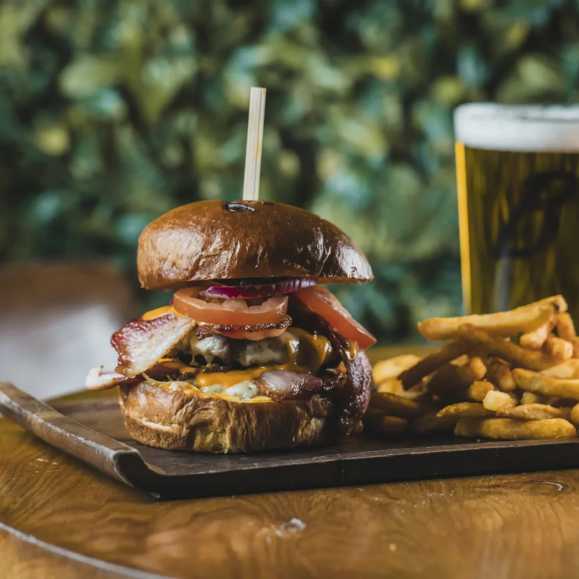 Belushi's bacon cheeseburger with fries and a cold pint of beer, classic World Cup match day food at a Belushi's sports bar