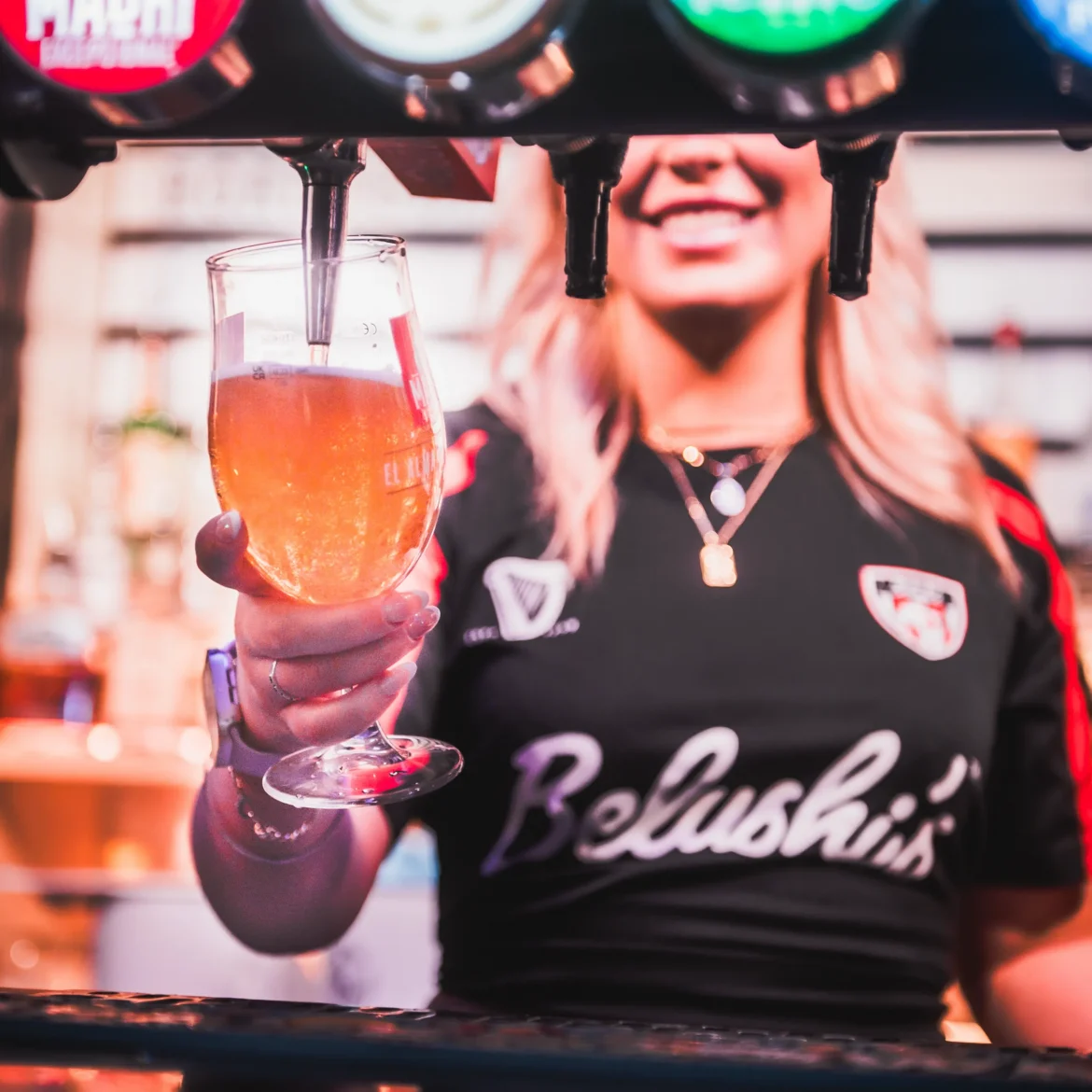 Belushi's bar staff serving craft beer on draught during a World Cup match, cold drinks and live football at Belushi's sports bars across Europe