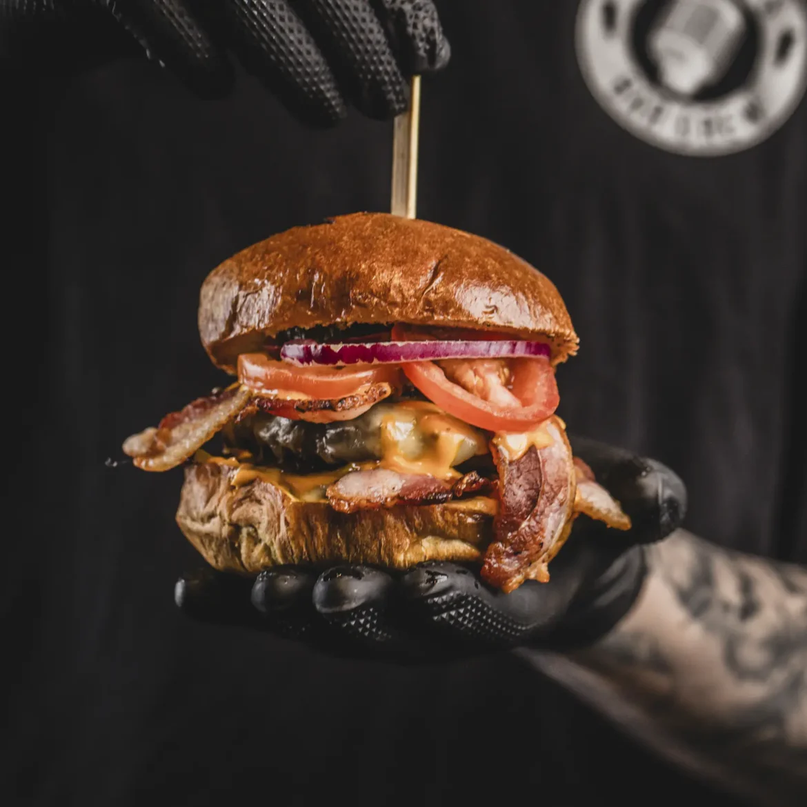 Belushi's chef presenting a handcrafted loaded bacon cheeseburger from the World Cup match day menu
