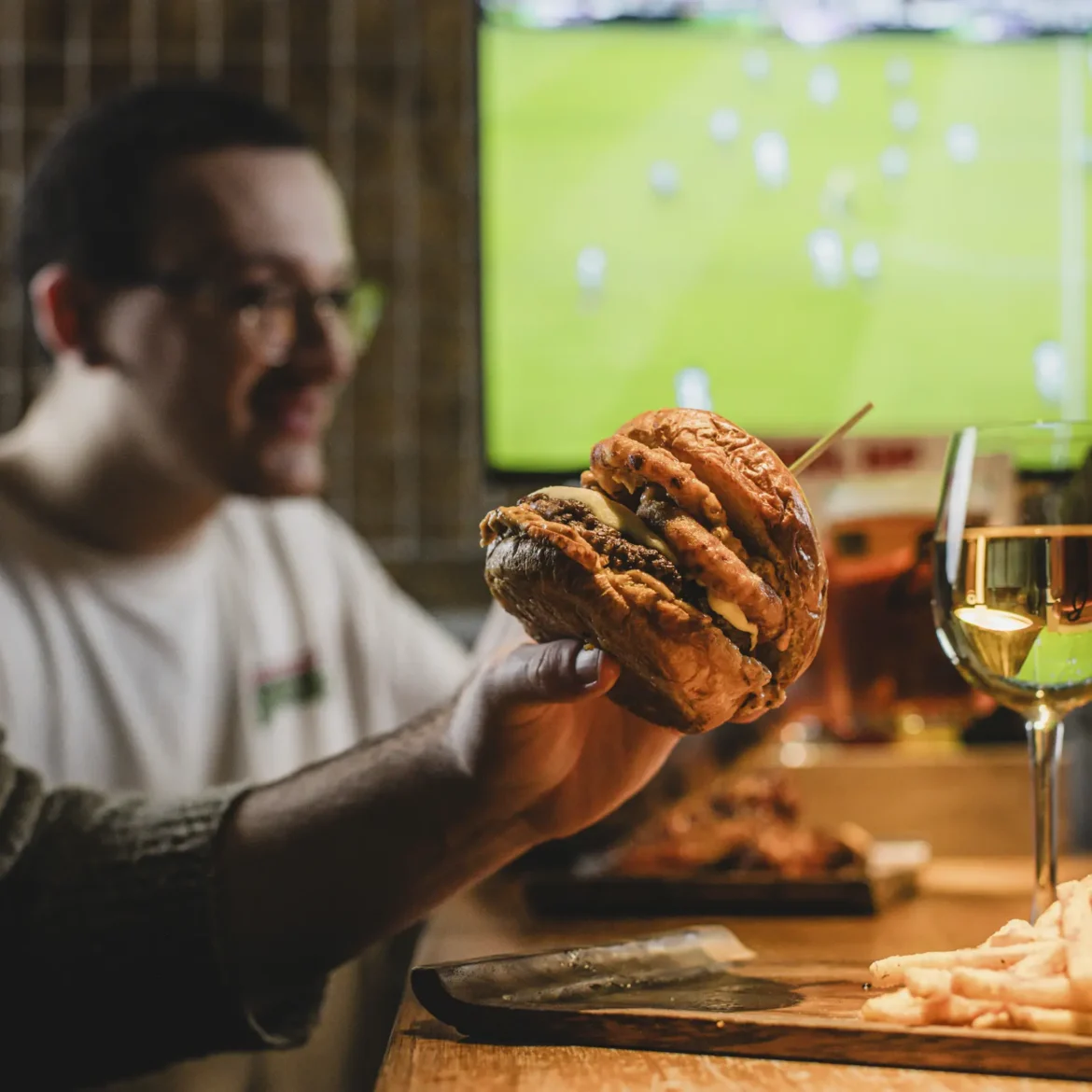 Loaded Belushi's burger with fries served at the table while watching the World Cup live at a Belushi's sports bar