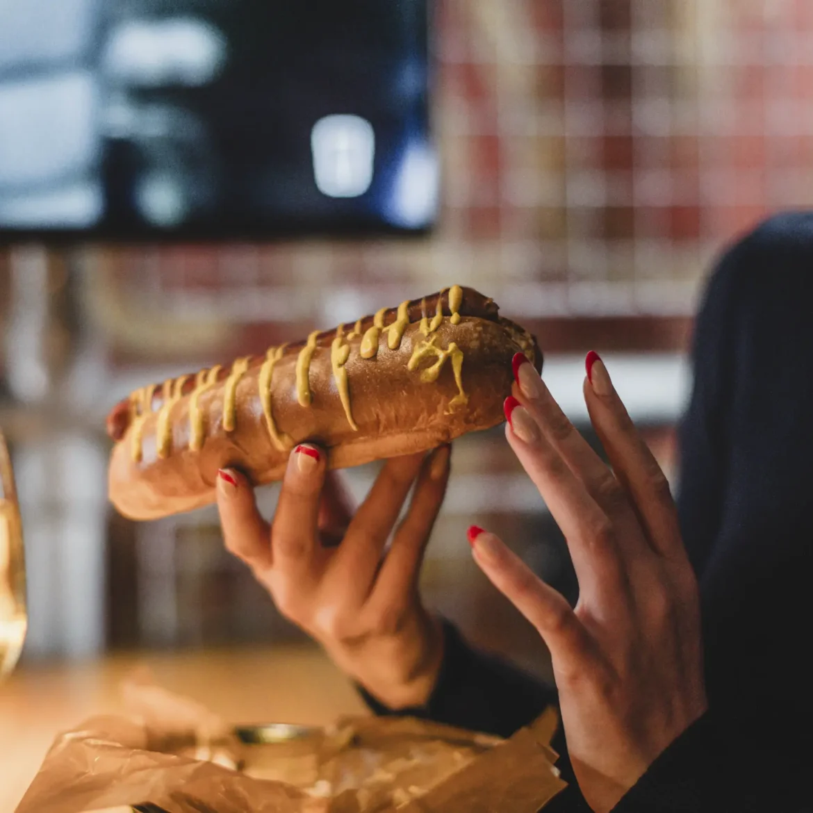 Belushi's NYC Dirty Dog hot dog with mustard served at the table during a World Cup match at a Belushi's sports bar