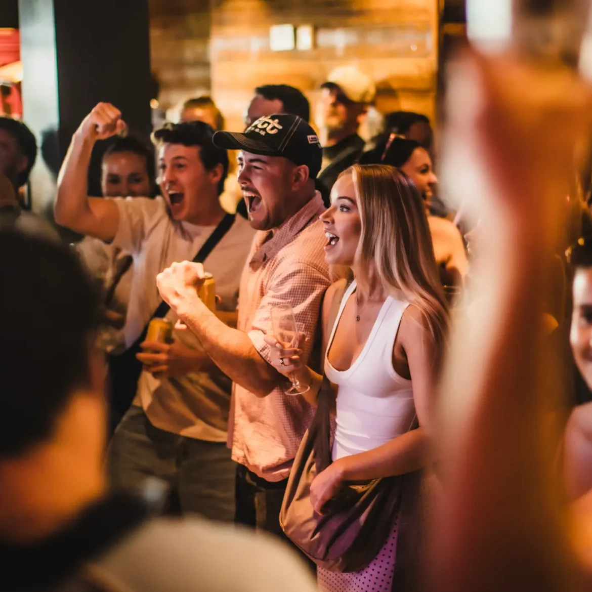 Fans celebrating a World Cup goal together at Belushi's sports bar, the kind of electric match day atmosphere you can only get watching live football in a crowd