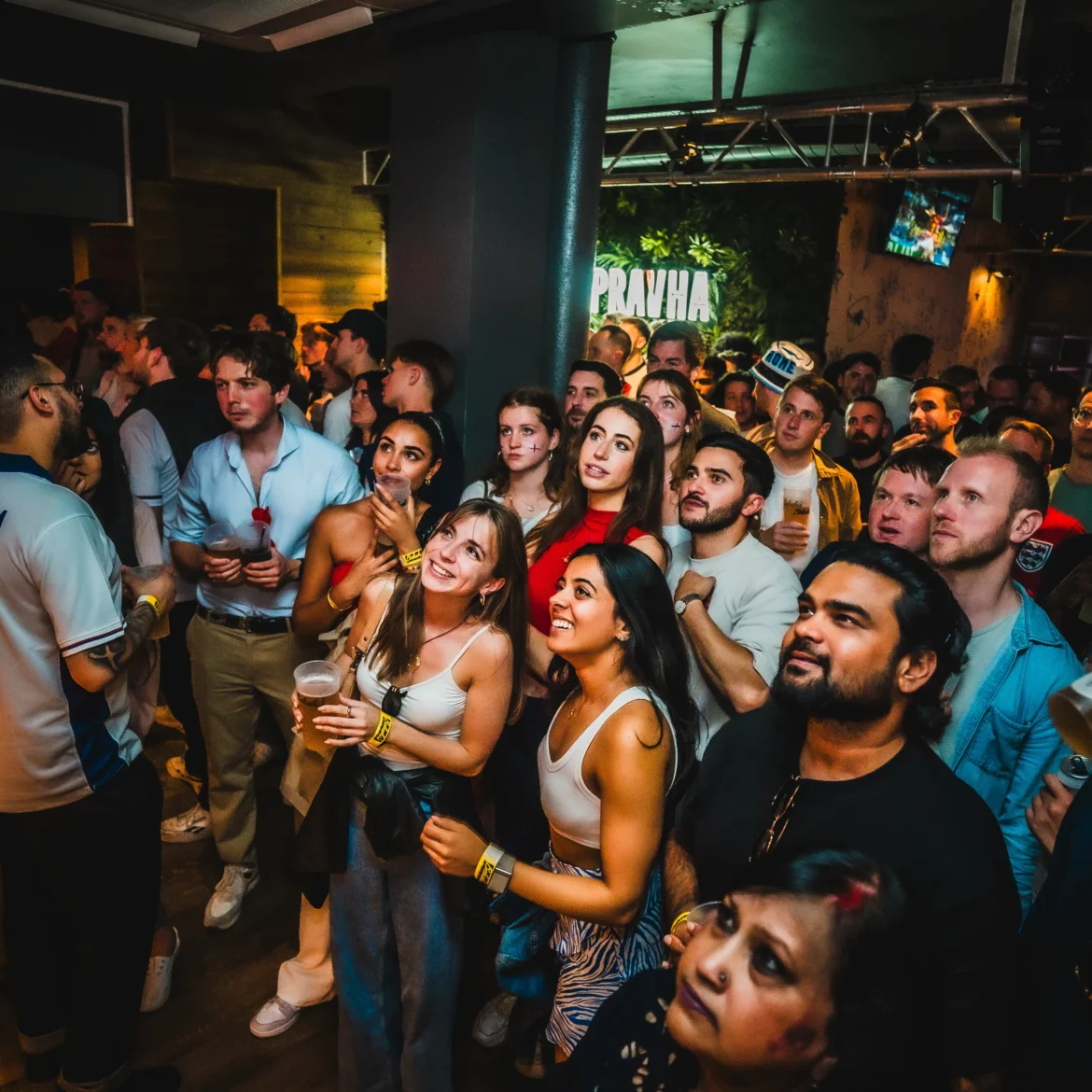 Diverse crowd of international football fans watching the World Cup live together at Belushi's sports bar generating an electric match day atmosphere