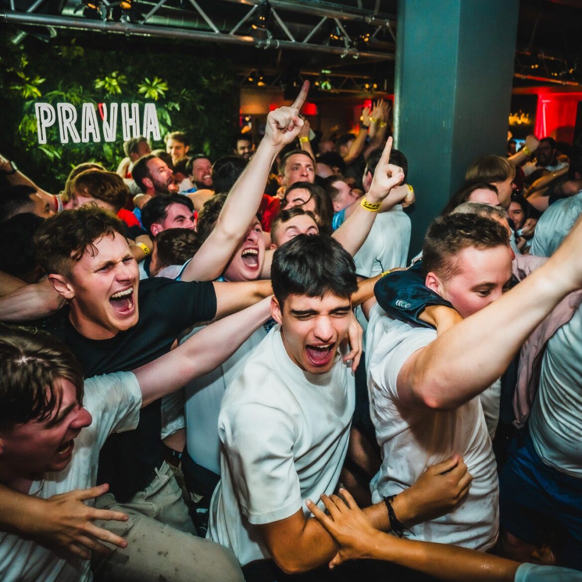 England fans cheering and pointing at Belushi's Newquay during a World Cup 2026 watch party, with a sold-out crowd packing the sports bar for the live football screening